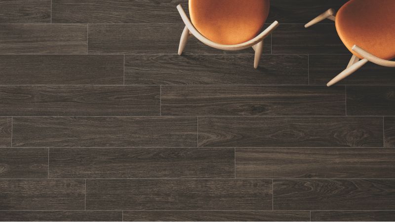 Closeup of a wood-look porcelain tile floor with a chair sitting on it