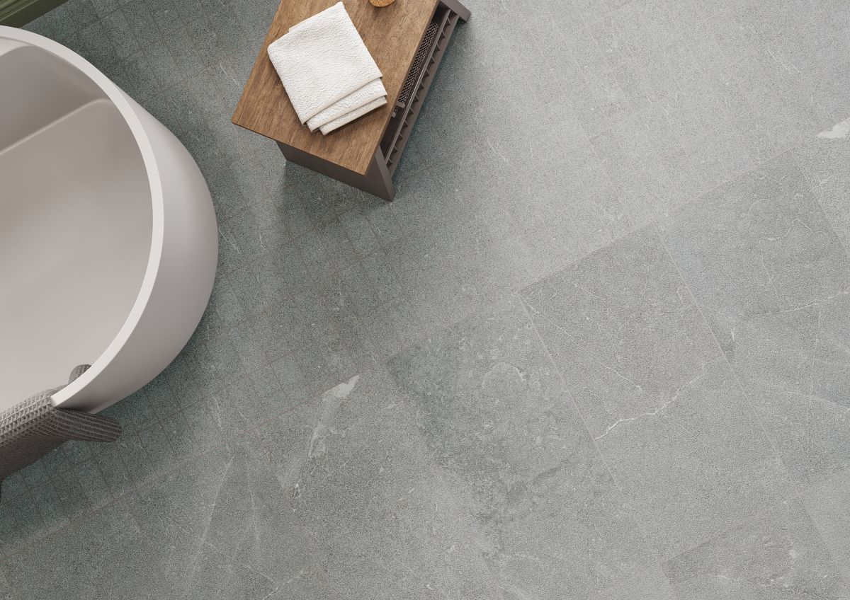 Overhead view showing the edge of a tub with a bench and towel showing porcelain stone tile 