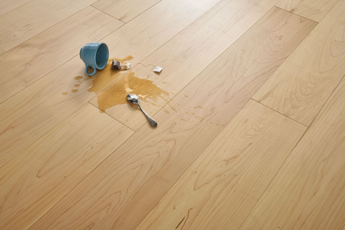Maple flooring with a spilled cup and spoon to show the waterproofing of densified hardwood flooring