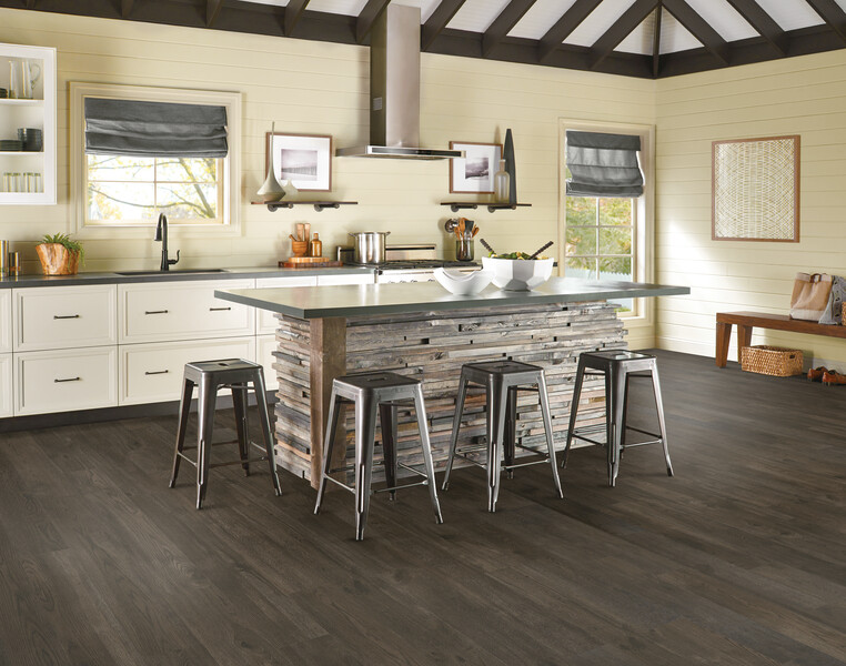 Kitchen with a stone-faced island and stools using luxury vinyl flooring