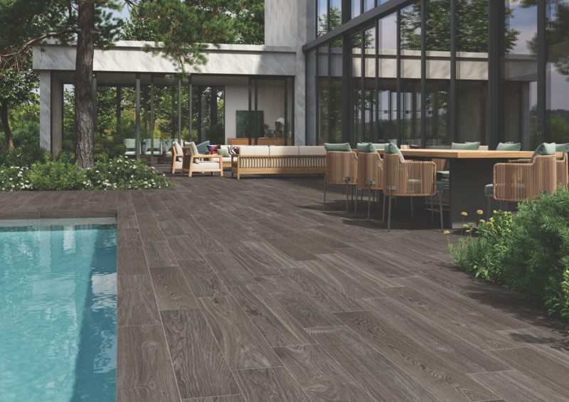 Patio area with a pool and wood-look porcelain tile deck to show the versatility of porcelain for indoor and outdoor use