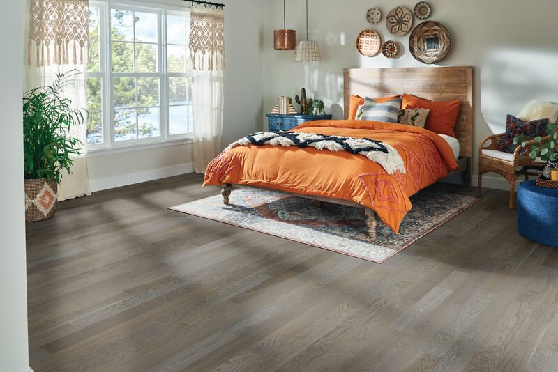 Bedroom with a large window and bed showing hardwood flooring